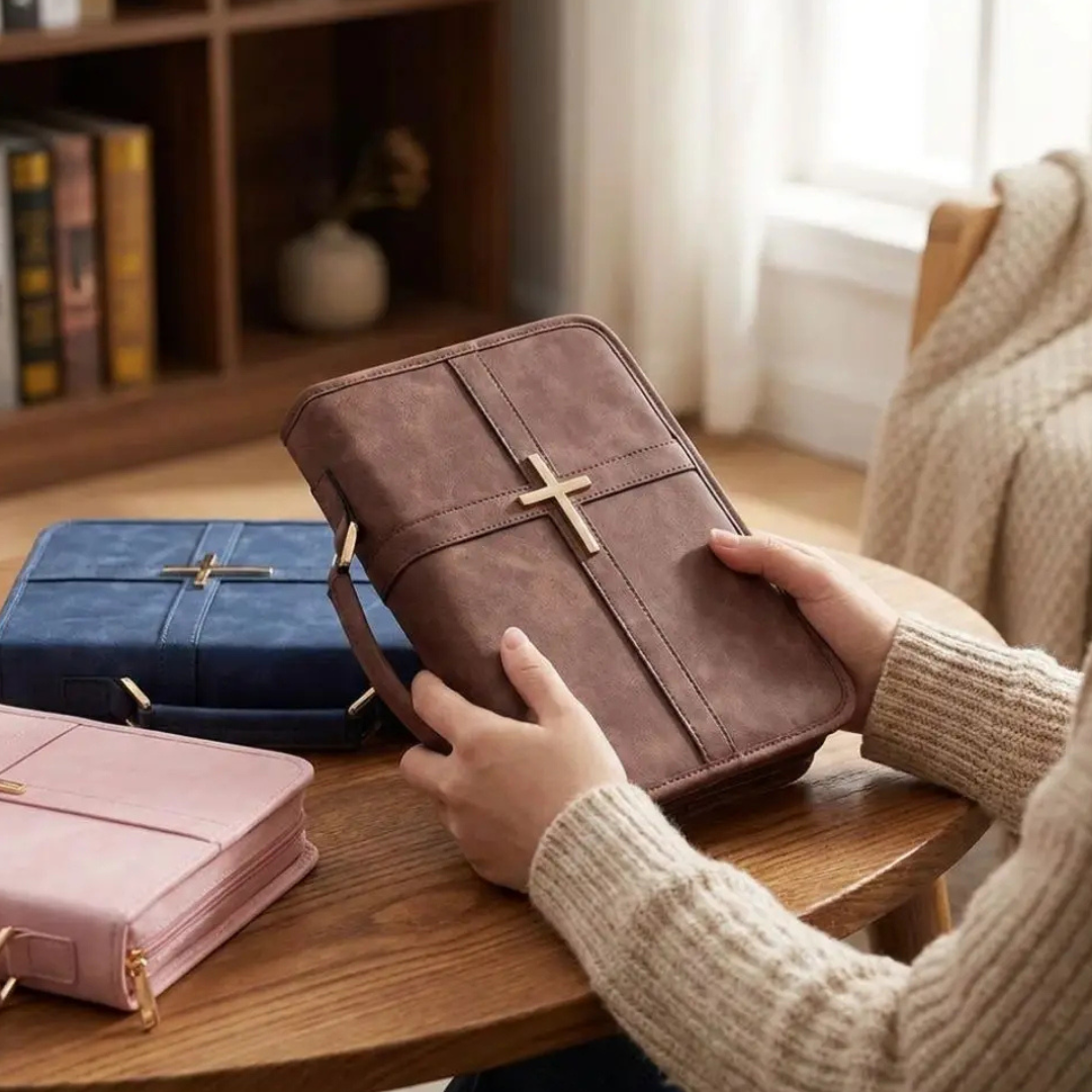 Person holding a brown Steadfast Cross Bible cover beside blue and pink covers