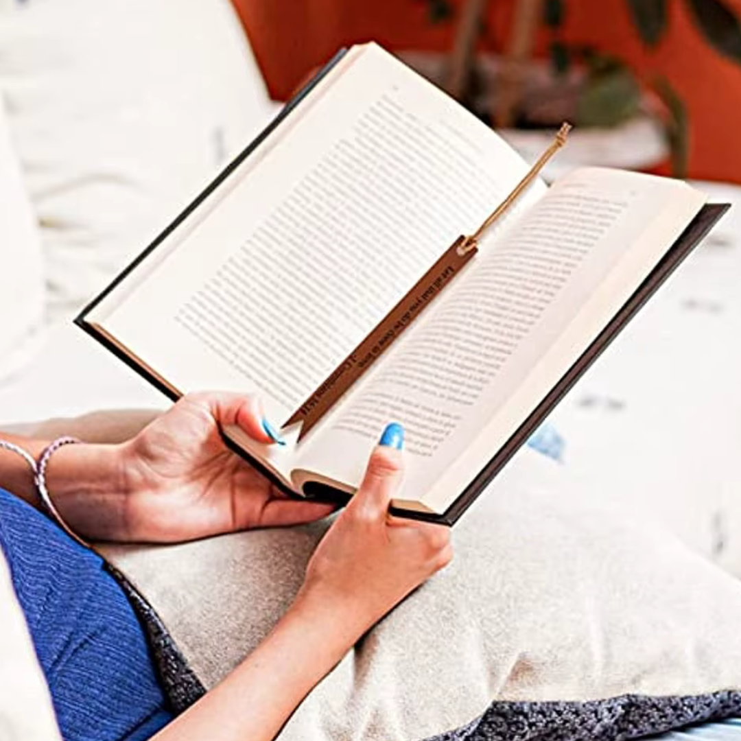 Brown Scripture Verse bookmark marking a page in an open book.